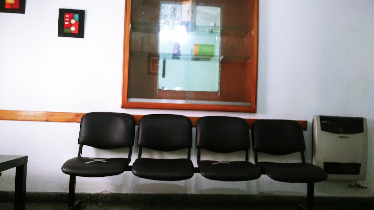 Sala de espera cálida con revestimiento de madera, sillones confortables y recepción de ODONTOLIFE